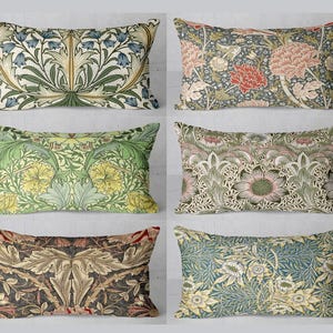 Op de afbeelding: Zes decoratieve kussens met bloemmotieven in tinten groen, geel, blauw, bruin en roze. De kussens zijn gerangschikt in twee rijen van drie.