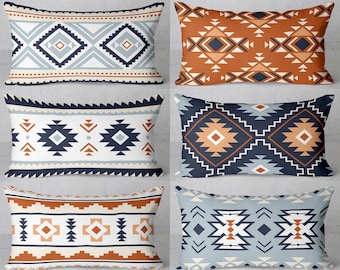 Puede incluir: Seis almohadas decorativas rectangulares con patrones geométricos en tonos azules, naranjas y blancos. Las almohadas están dispuestas en dos filas de tres.