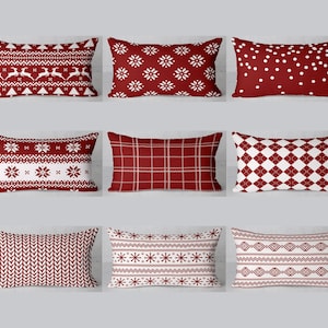 Può includere: Set di dieci cuscini rossi e bianchi con vari motivi geometrici. I motivi includono fiocchi di neve, punti, quadri e zigzag.