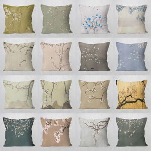 Peut inclure: Ensemble de coussins décoratifs avec des motifs floraux. Chaque coussin présente une illustration de style aquarelle de branches fleuries dans diverses couleurs, dont le blanc, le bleu et le rouge, sur des fonds mats.