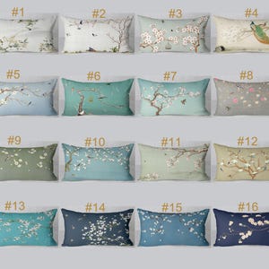 May include: A collection of sixteen rectangular throw pillows with various floral and bird designs. The pillows feature a range of colors, including blue, green, and beige, with detailed illustrations of cherry blossoms, birds, and peacocks.