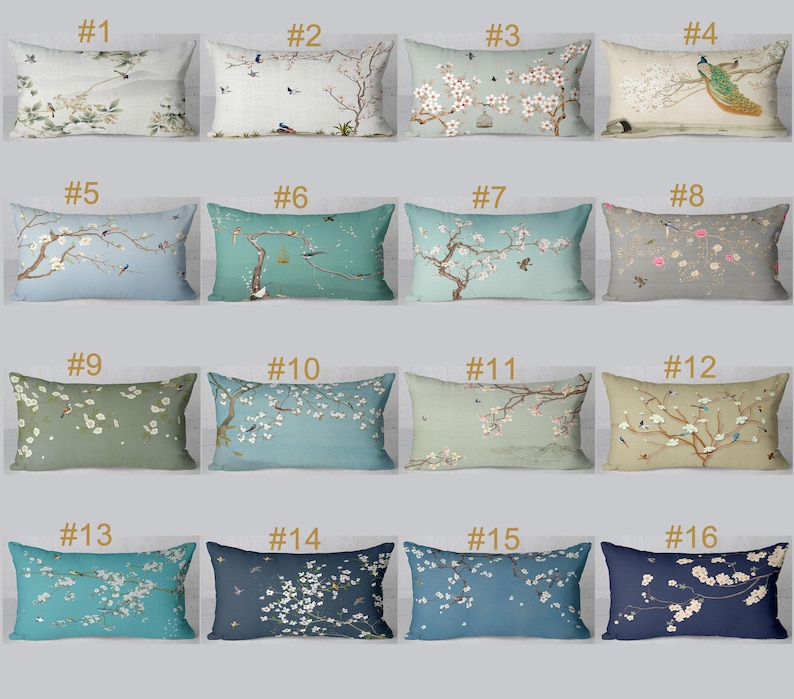 May include: A collection of sixteen rectangular throw pillows with various floral and bird designs. The pillows feature a range of colors, including blue, green, and beige, with detailed illustrations of cherry blossoms, birds, and peacocks.