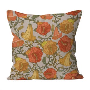 May include: Square throw pillow with a floral pattern. The design features orange, yellow, and red flowers with green leaves and vines on a light beige background. The pillow is a decorative item for a bed or sofa.