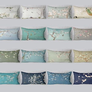May include: A collection of rectangular throw pillows with floral and bird designs. The pillows feature various color schemes, including light blue, green, and navy, with detailed illustrations of cherry blossoms, birds, and branches.