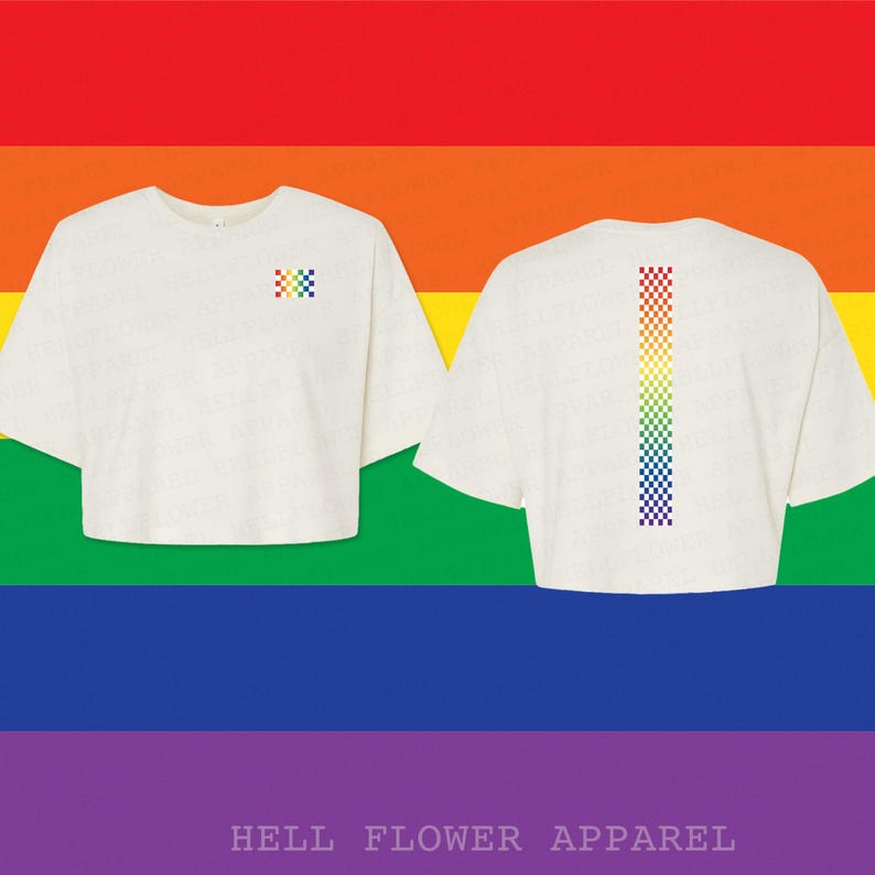 Pu&ograve; includere: Una t-shirt corta bianca con un piccolo quadrato a scacchi arcobaleno sul petto a sinistra e una lunga striscia verticale a scacchi arcobaleno centrata sul retro. Il capo presenta maniche corte e uno scollo rotondo su sfondo arcobaleno.