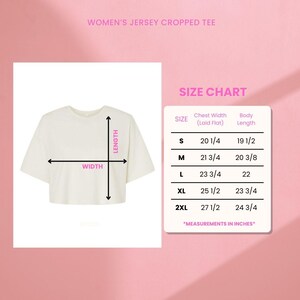 Pu&ograve; includere: Una t-shirt corta in jersey color crema con una tabella delle taglie che mostra la larghezza del torace e la lunghezza del corpo in pollici per le taglie dalla S alla 2XL. La tabella elenca le dimensioni specifiche per ogni taglia, come 20 1/4 pollici.