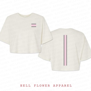 Può includere: Due magliette bianche crop con un design a righe rosa, grigio e nero. Una maglietta ha il design a righe sul davanti, l'altra ha il design a righe sul retro.