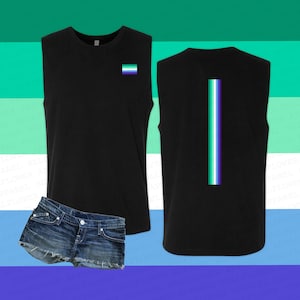 May include: Black sleeveless shirt with a green, blue, and purple stripe on the back and a small green, blue, and purple flag on the front. The shirt is paired with denim shorts.