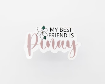 Könnte beinhalten: Ein weißer Aufkleber mit rosa Umrandung und einer kleinen weißen Blume mit grünen Blättern. Der Text auf dem Aufkleber lautet "My best friend is Pinay".