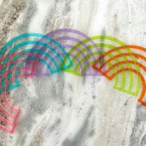 Pu&ograve; includere: Un set di sei archi in plastica arcobaleno, ognuno di un colore diverso, tra cui rosa, blu, viola, verde, giallo e arancione. Gli archi sono disposti a forma di semicerchio, con l'arco pi&ugrave; grande in basso e l'arco pi&ugrave; piccolo in alto.
