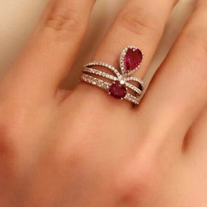 Könnte beinhalten: Ein Ring aus Weißgold mit zwei Rubinen und einer Diamantfassung.