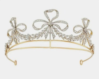 Könnte beinhalten: Eine goldene Tiara mit einem zarten Design aus Schleifen und Blättern, verziert mit funkelnden Diamanten.