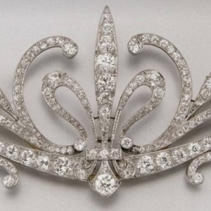 Può includere: Un fermaglio in argento e diamanti con un design floreale. Il fermaglio è incastonato con piccoli diamanti e ha un design delicato e intricato.
