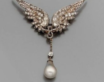 May include: A silver and diamond brooch with a large pearl drop pendant. The brooch is shaped like a pair of angel wings.
