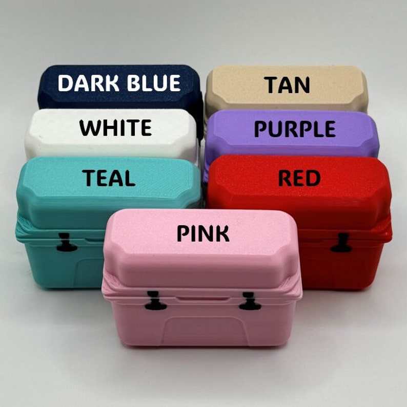May include: A collection of small, colorful storage boxes in various colors, including dark blue, white, teal, pink, tan, purple, and red. Each box has a matching lid with the color name printed on it.