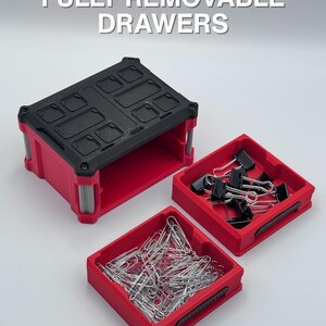 May include: A red and black storage container with the text "FULLY REMOVABLE DRAWERS". The container has a black top and red base, with two removable red drawers filled with paper clips and binder clips.