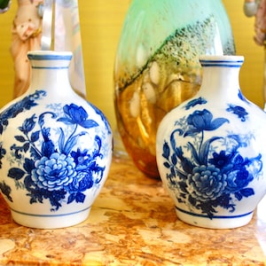 Vintage pair of oriental porcelain vases hand decorated with a blue bouquet of spring flowers finished with a glossy glaze