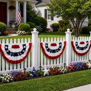 May include: Three pleated fabric bunting fans featuring a red, white, and blue color scheme with white stars on a blue stripe. The bunting is attached to a white picket fence, accompanied by several decorative star-shaped ornaments in red, white, and blue.