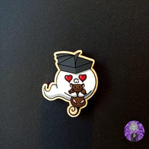 Könnte beinhalten: Ein weißer Geist mit einem schwarzen Papierhut hält eine braune Maus. Der Geist hat rote Herzen als Augen.