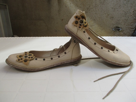 Women's vintage cream kickers with flower detail.
