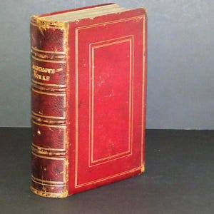 May include: A red leather-bound book with gold accents and the text "Dickens's Works" on the spine.