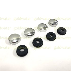 May include: A set of six chrome-plated screw caps and three black rubber washers. The screw caps are round and have a smooth, shiny finish. The rubber washers are flat and have a hole in the center.