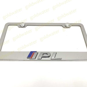 May include: Silver license plate frame with a raised, chrome "IPL" logo in blue, red, and white.