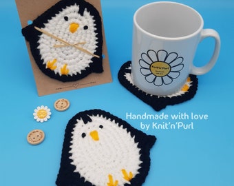 Peut inclure: Ensemble de trois dessous de tasse en crochet en forme de pingouin, en fil noir et blanc avec des accents jaunes. Les dessous de tasse sont faits à la main et portent le texte "Knit'n'Purl" sur l'emballage et le dessous de tasse.
