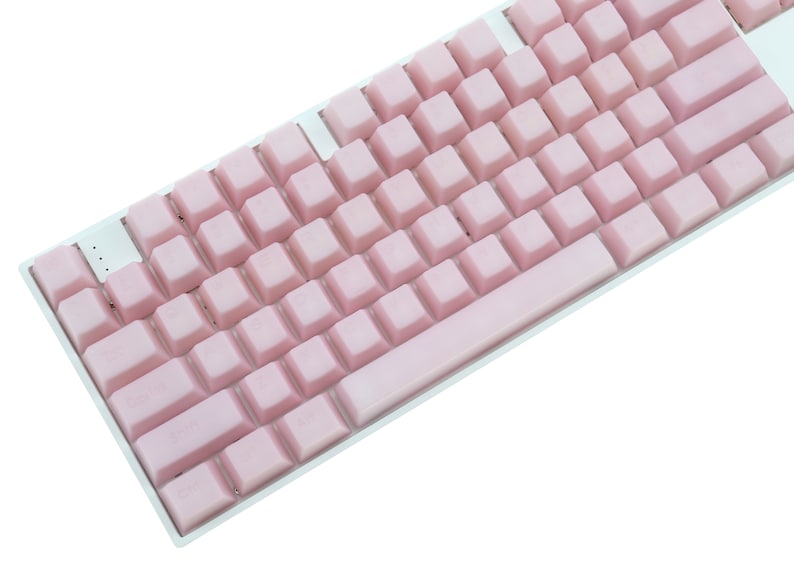 K&ouml;nnte beinhalten: Eine wei&szlig;e mechanische Tastatur mit hellrosa Tastenkappen. Die Tastenkappen haben eine einheitliche Pastellfarbe, und die Tastatur hat ein Standardlayout. Die Tasten sind quadratisch und gleichm&auml;&szlig;ig angeordnet, was eine saubere und moderne &Auml;sthetik schafft.