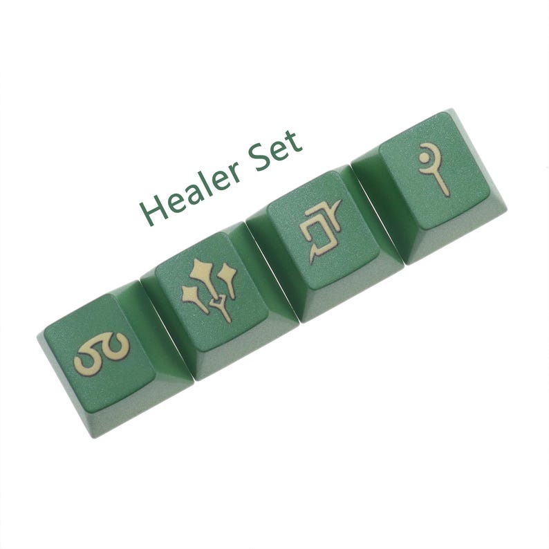 Puede incluir: Un conjunto de cuatro teclas verdes con s&iacute;mbolos dorados. Las teclas est&aacute;n etiquetadas como "Healer Set" y presentan s&iacute;mbolos que representan la magia de curaci&oacute;n.