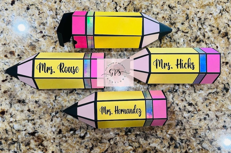 May include: Four yellow pencil-shaped boxes with pink, black, and blue accents. The boxes are decorated with the names "Mrs. Rouse", "Mrs. Hicks", "Mrs. Hernandez", and a logo that says "GPS Creations".