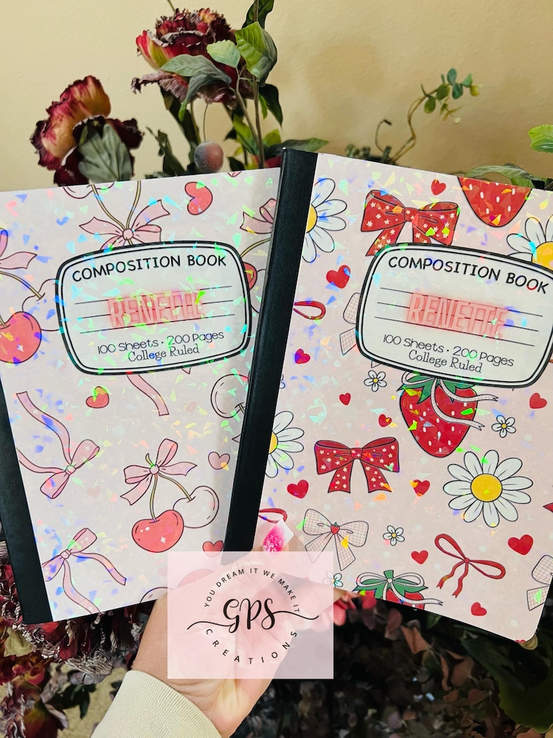 Peut inclure: Deux cahiers de composition avec des couvertures roses orn&eacute;es de n&oelig;uds, de cerises et de marguerites. Les cahiers portent les inscriptions "COMPOSITION BOOK" et "RENEGADE". Chaque cahier contient 100 feuilles et 200 pages de papier r&eacute;gl&eacute;.