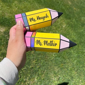 May include: Two yellow and pink pencil-shaped boxes with black text. The top box says "Ms. Huynh" and the bottom box says "Ms. Mathur".