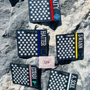 May include: Five black and white glitter square tags with different names and thin colored stripes. The names are "Baity", "Hatter", "Swann", "Estrada", and "A. Soul".
