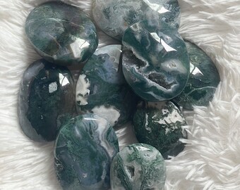 May include: A collection of eight green moss agate palm stones. The stones are smooth and polished, with a variety of green and white patterns.