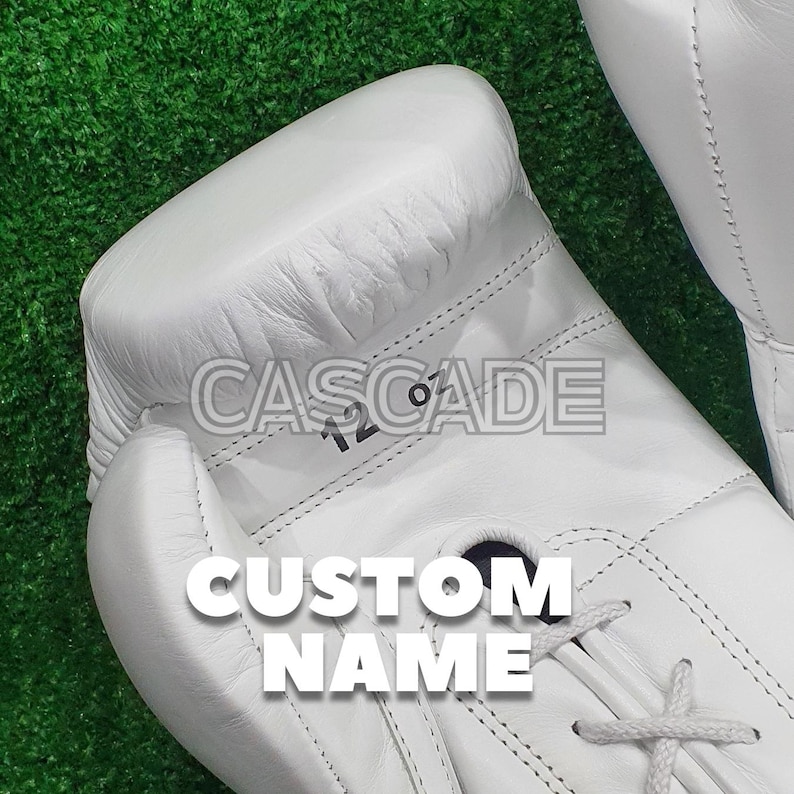 Peut inclure: Gants de boxe en cuir blanc avec le texte "CASCADE" et "CUSTOM NAME" imprim&eacute; dessus. Les gants sont de 12 oz.