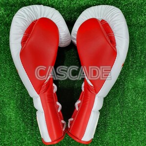 Peut inclure: Une paire de gants de boxe rouges et blancs avec des lacets blancs. Les gants sont dispos&eacute;s en forme de c&oelig;ur.