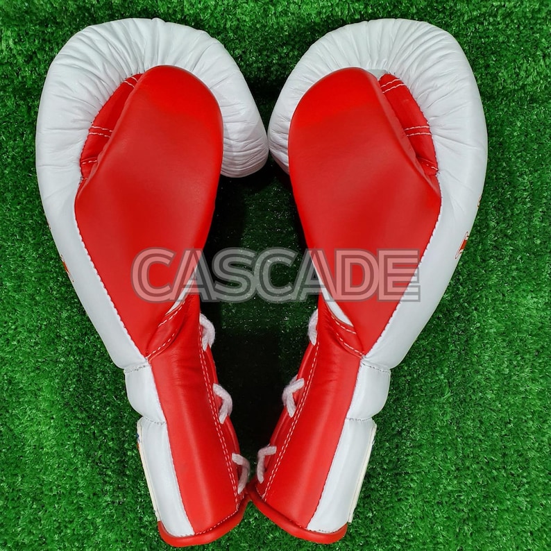 Peut inclure: Une paire de gants de boxe rouges et blancs avec des lacets blancs. Les gants sont dispos&eacute;s en forme de c&oelig;ur.