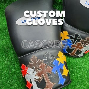 K&ouml;nnte beinhalten: Schwarze Handschuhe mit bunten Kreuzdesigns. Auf den Handschuhen steht der Schriftzug "CUSTOM GLOVES" und "CASCADE". Die Kreuze sind in verschiedenen Farben gehalten: Rot, Gelb, Blau, Braun und Grau.