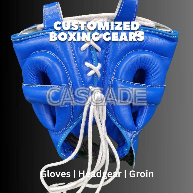 May include: Blue boxing headgear with white laces and a white CASCADE logo. The headgear has ear and cheek protection.  CUSTOMIZED BOXING GEARS is written at the top. Gloves | Headgear | Groin is written at the bottom.