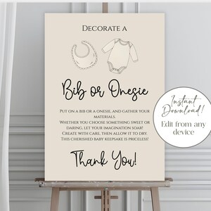 Puede incluir: Un letrero beige sobre un caballete con el texto "Decora un babero o un body". El letrero incluye dibujos lineales de un babero y un body. El texto fomenta la creatividad y menciona que el recuerdo no tiene precio. Un gráfico circular de "Descarga instantánea" está a la derecha.