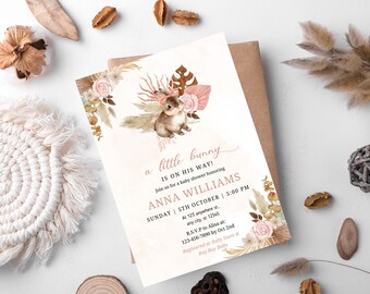 Pode incluir: Um convite para um chá de bebê com uma ilustração em aquarela de um coelho com um laço rosa. O convite é decorado com elementos florais e o texto "a little bunny is on his way!"  Junte-se a nós para um chá de bebê em homenagem a Anna Williams. Domingo, 5 de outubro | 17:00. No 125 anywhere st., any city, st 12345. R.S.V.P para Alisa em: 123-456-7890 até 2 de outubro. Registrado na Baby Store & Buy Buy Baby.