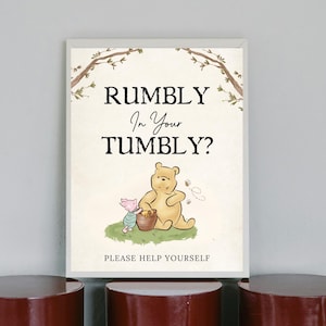Op de afbeelding: Een Winnie de Poeh-themabord met de tekst "Rumbly in your Tumbly?" en een cartoonafbeelding van Winnie de Poeh en Biggetje. Het bord zegt ook "Please help yourself".