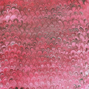May include: A close-up of a decorative paper with a repeating pattern of stylized, feather-like shapes. The color palette includes shades of pink, red, white, and dark brown, creating a textured, layered effect. The overall design is reminiscent of marbling.
