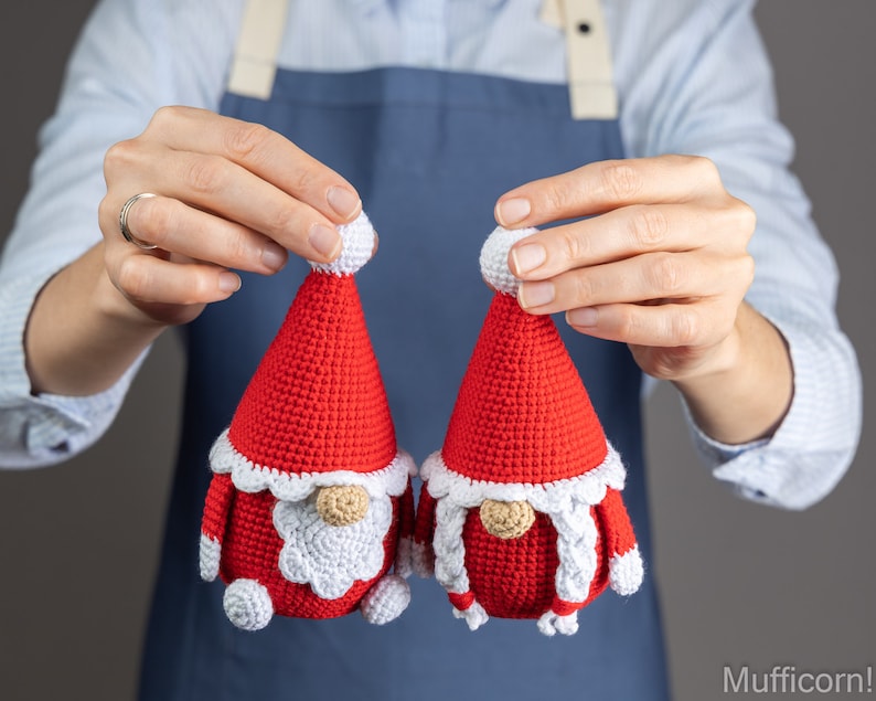 May include: Two crocheted gnome ornaments in red and white. The gnomes have white beards and white hats with white pom-poms.