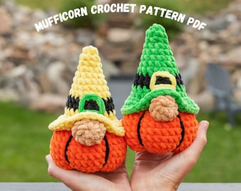 May include: Two crocheted pumpkin gnomes, one with a green hat and the other with a yellow hat. Both gnomes have a brown beard and a green belt. The gnomes are sitting on a person's hand. "MUFFICORN CROCHET PATTERN PDF" is written in white letters on a green background at the top of the image.