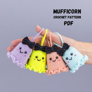 May include: Four colorful crocheted ghost-like figures with black bows and smiling faces. The figures are in shades of purple, yellow, peach, and blue. The text "MUFFICORN CROCHET PATTERN PDF" is displayed above the figures.