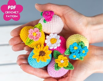 May include: Six crocheted Easter eggs in various colours and flower designs. The eggs are pink, yellow, blue, and white with crocheted flowers in pink, yellow, white, and blue.