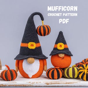 Può includere: Due gnomi all'uncinetto con cappelli a punta neri e arancioni, fibbie gialle e nasi rotondi. Lo gnomo più alto ha una barba bianca e una zucca appesa. Testo MUFFICORN CROCHET PATTERN PDF. Include piccole zucche a righe.