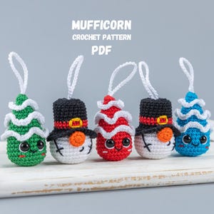 May include: Five crocheted Christmas decorations, including a snowman, a Christmas tree, and three candy canes. The decorations are all white with different coloured accents. The decorations are hanging from a white wooden tray. The text "MUFFICORN CROCHET PATTERN PDF" is at the top of the image.